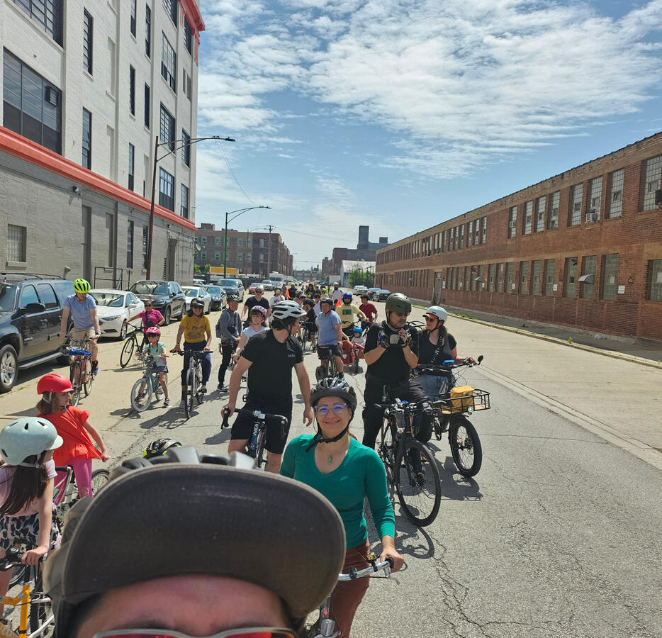 Untitled Dozens of cyclists on bikes on a Chicago road shown from the front.