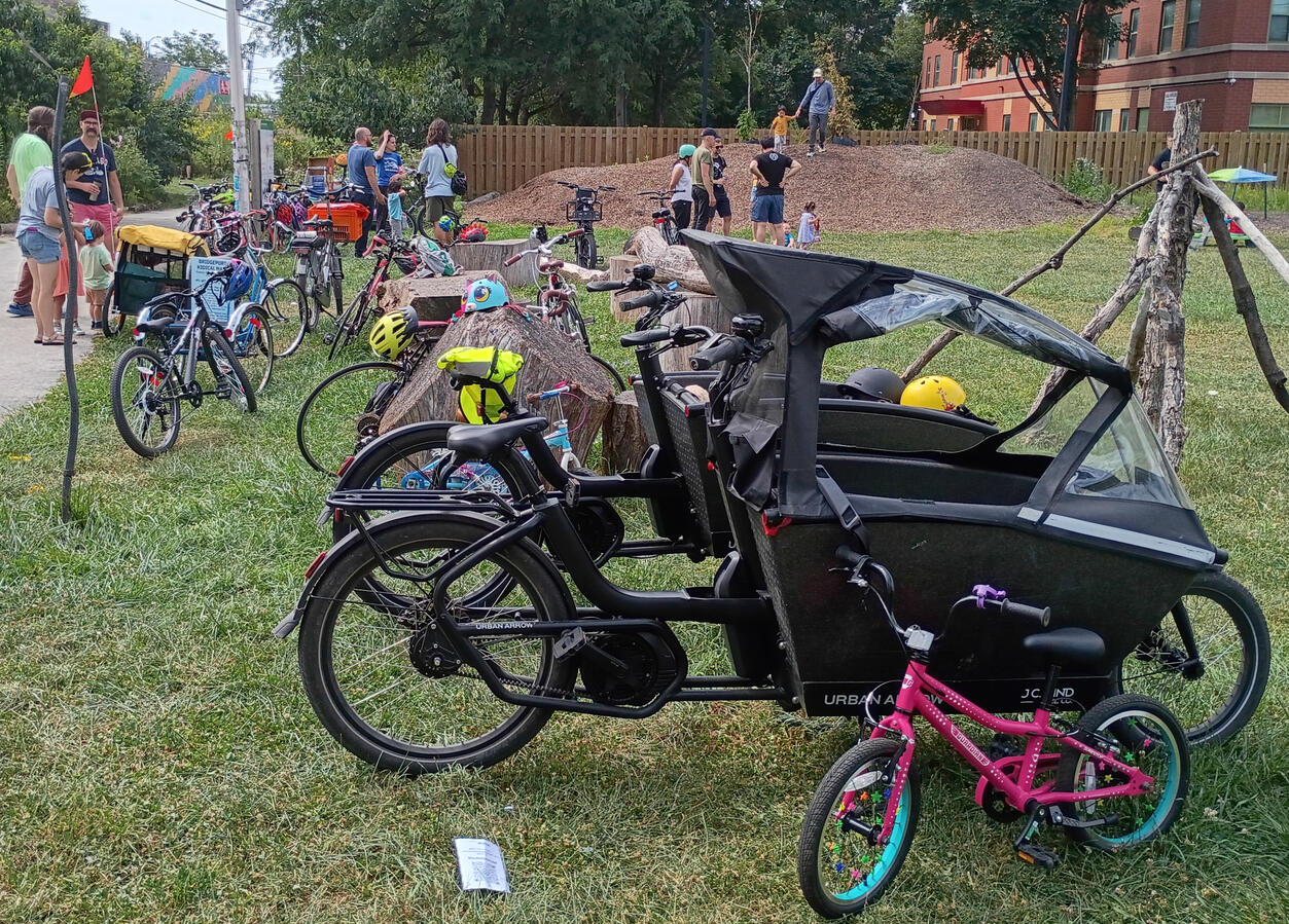Lots of bikes including two urban arrows with people talking to each other in the background